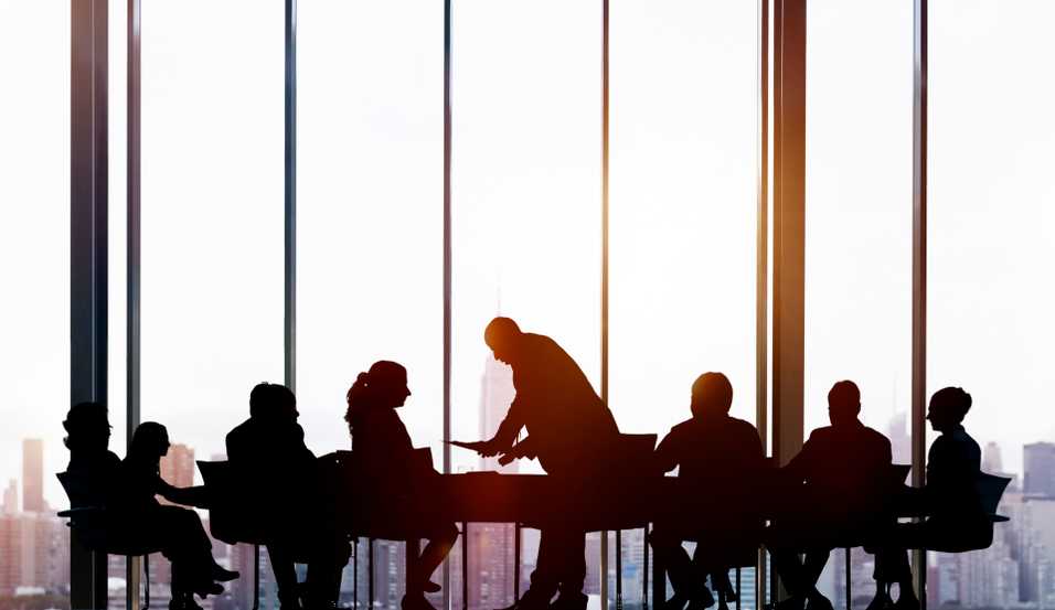 Sala konferencyjna z przeszkloną ścianą i z grupą osób siedzącą przy stole