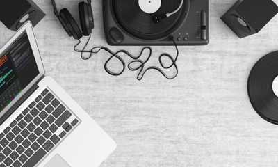 Laptop, gramofon, słuchawki na biurku
